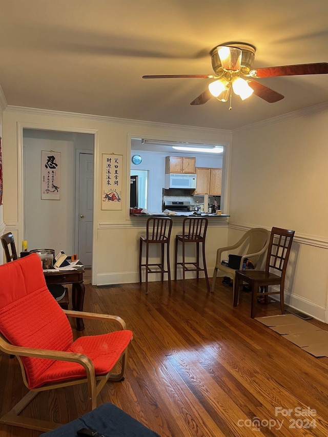 living room with dark wood-style flooring, a ceiling fan, and crown molding
