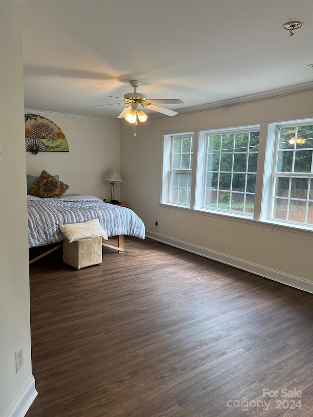 bedroom featuring baseboards, ornamental molding, a ceiling fan, and dark wood-type flooring