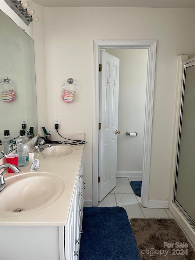 bathroom featuring a stall shower, tile patterned flooring, and a sink