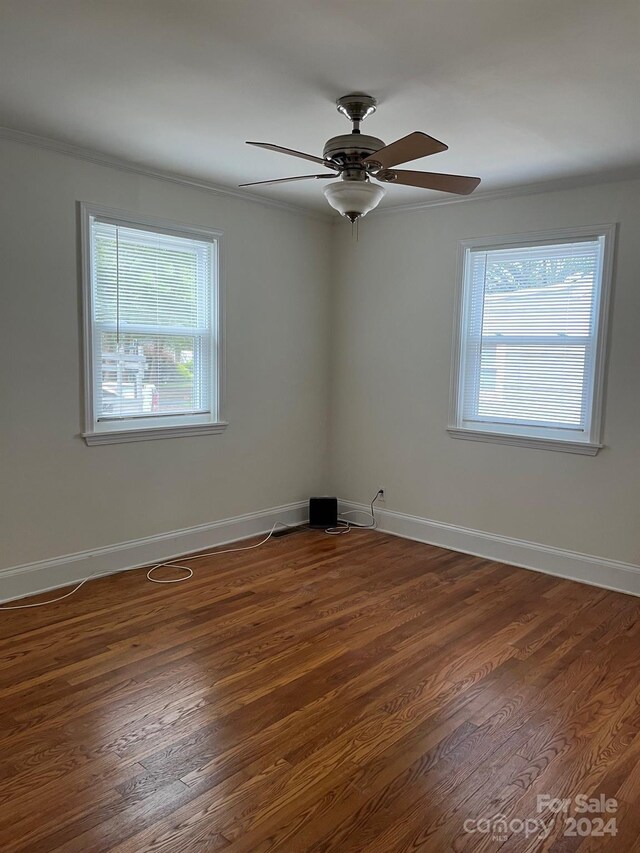 unfurnished room with ornamental molding, ceiling fan, wood finished floors, and plenty of natural light