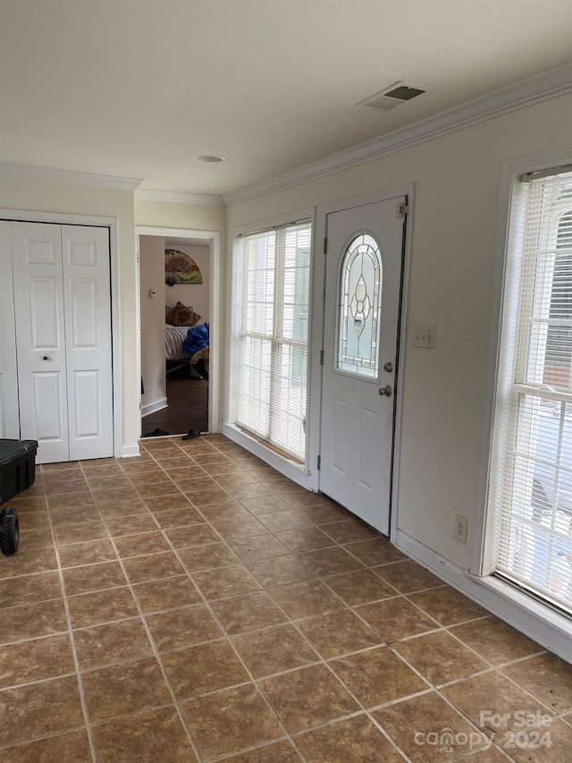 foyer featuring visible vents, ornamental molding, and a wealth of natural light
