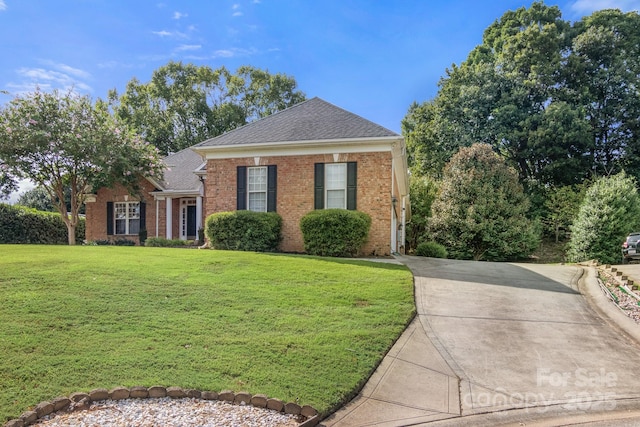 view of front of house with brick siding, a front lawn, and a shingled roof