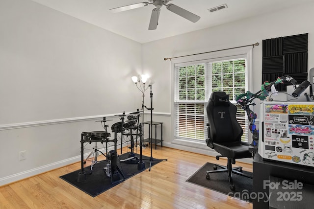 office featuring hardwood / wood-style flooring, baseboards, visible vents, and ceiling fan