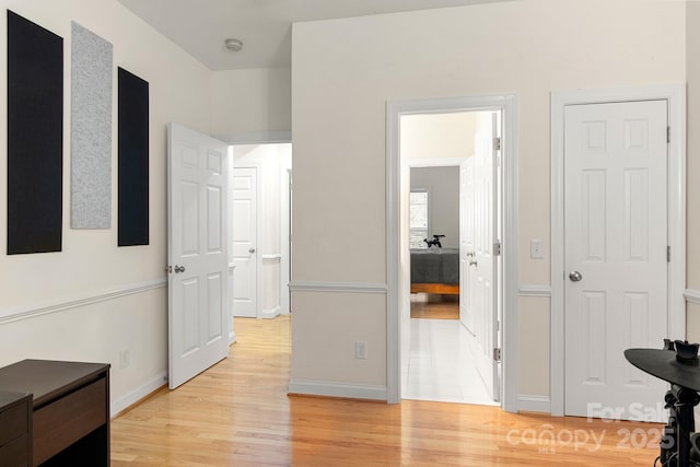 hall featuring light wood-style floors and baseboards