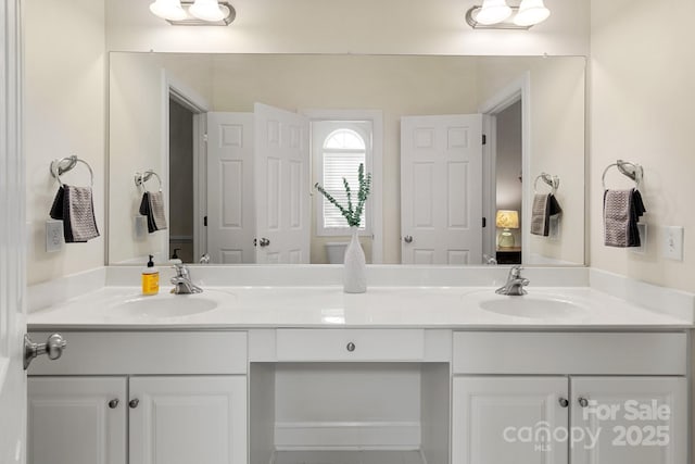 full bathroom with a sink and double vanity