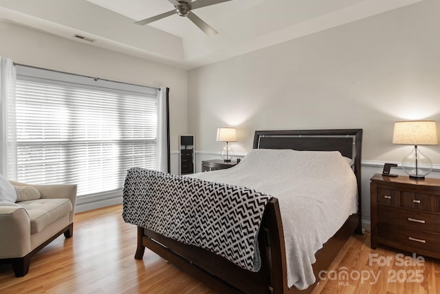 bedroom featuring wood finished floors, visible vents, and ceiling fan