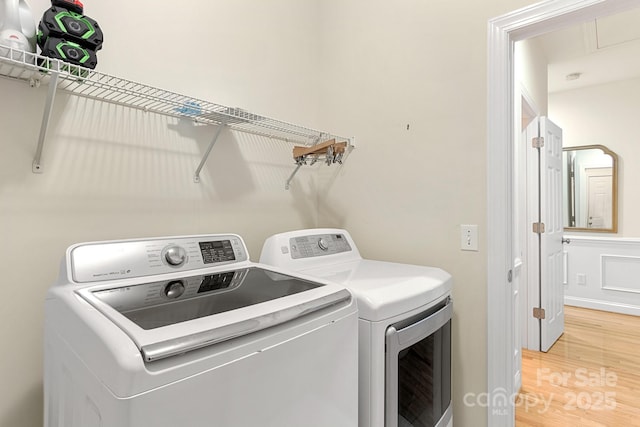 washroom with laundry area, light wood-style flooring, and separate washer and dryer