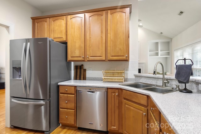 kitchen featuring a sink, stainless steel appliances, brown cabinets, and visible vents