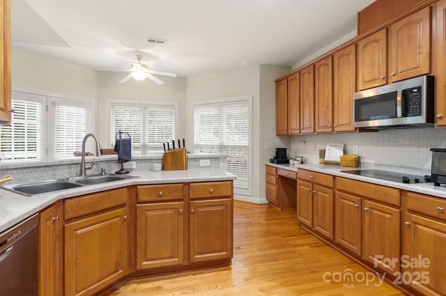 kitchen featuring visible vents, brown cabinets, stainless steel appliances, a ceiling fan, and a sink