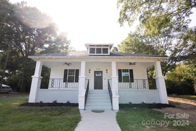 bungalow featuring a front lawn, covered porch, and ceiling fan