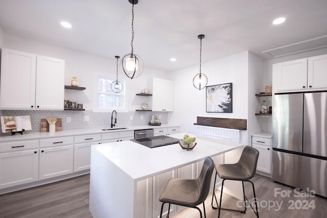 kitchen with backsplash, stainless steel appliances, sink, hardwood / wood-style flooring, and white cabinets