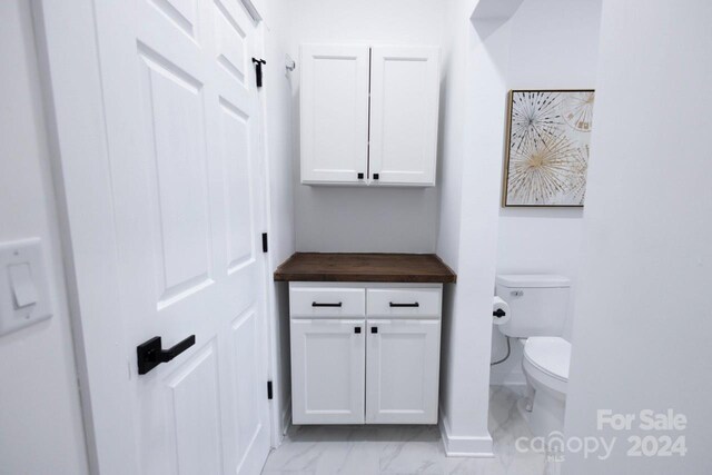 bathroom with toilet and tile patterned floors