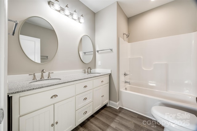 full bathroom with wood-type flooring, tub / shower combination, vanity, and toilet