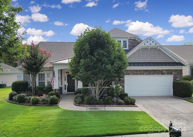 view of front of house featuring a garage, covered porch, a front lawn, and central AC