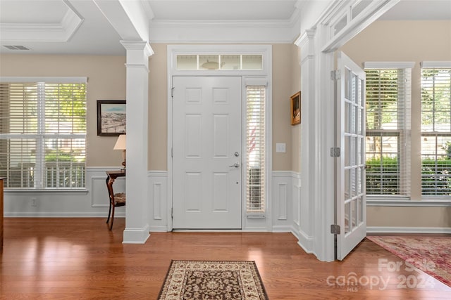 entryway featuring crown molding, wood-type flooring, and ornate columns