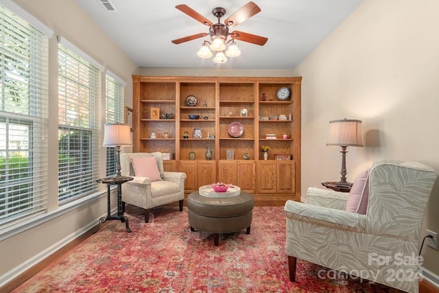 sitting room with ceiling fan and wood-type flooring