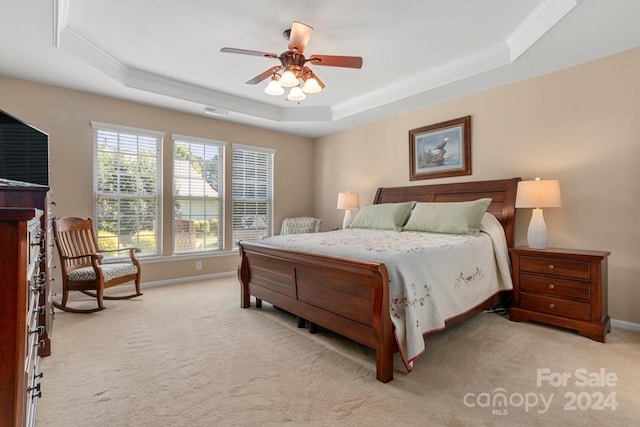 bedroom featuring a tray ceiling, ceiling fan, light colored carpet, and ornamental molding