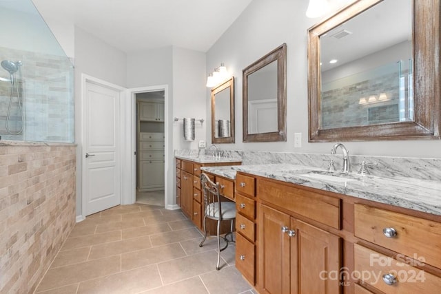 bathroom featuring vanity, tile walls, a tile shower, and tile patterned flooring