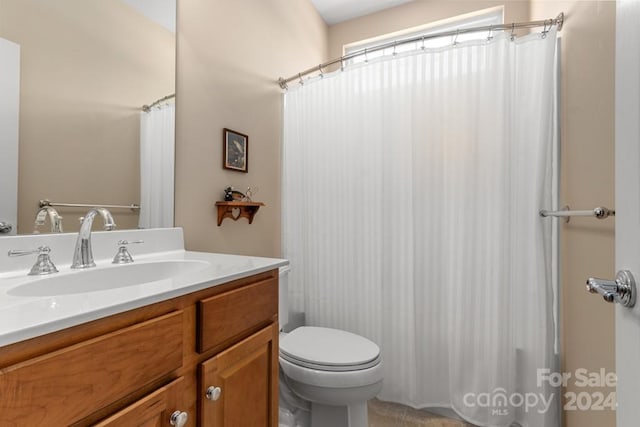 bathroom featuring curtained shower, toilet, and vanity