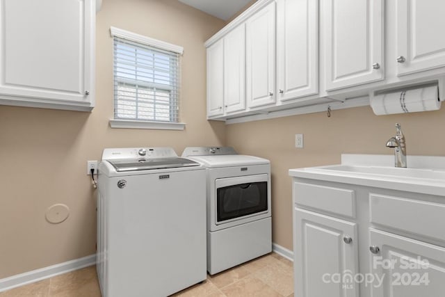 washroom featuring cabinets, washing machine and dryer, light tile patterned floors, and sink