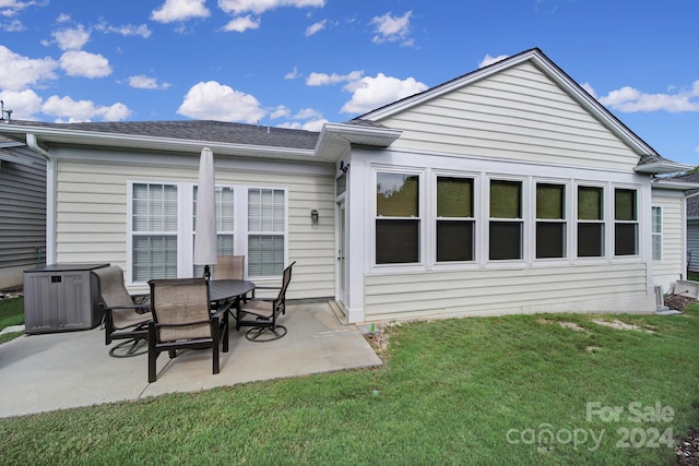 back of property with a patio area and a lawn