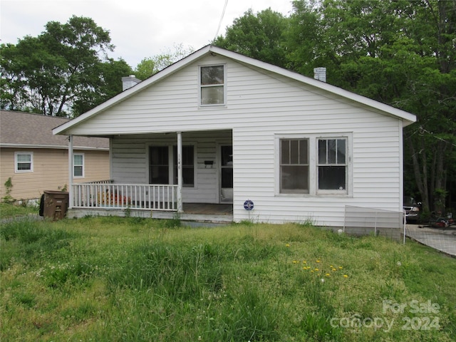 view of front of property featuring covered porch and a front yard