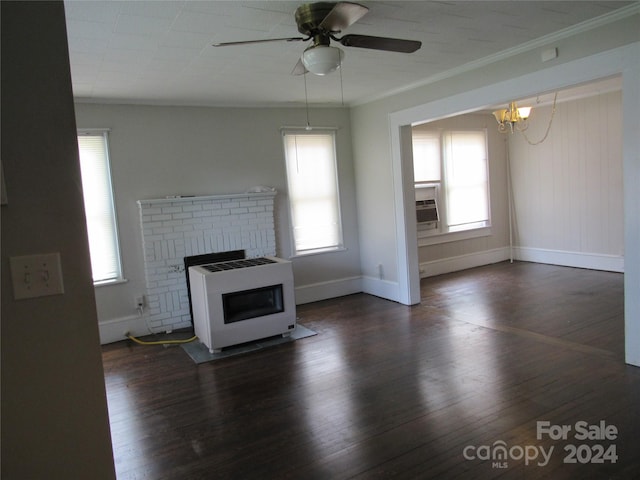 unfurnished living room with a fireplace, ceiling fan with notable chandelier, crown molding, heating unit, and dark hardwood / wood-style floors