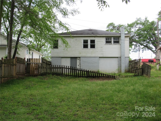 rear view of house featuring a lawn