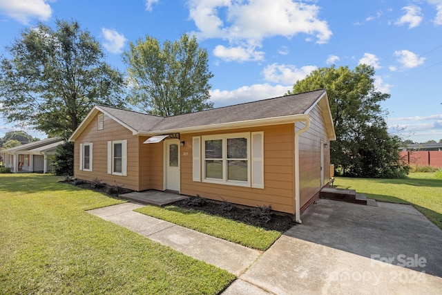 view of front of home featuring a shingled roof and a front yard