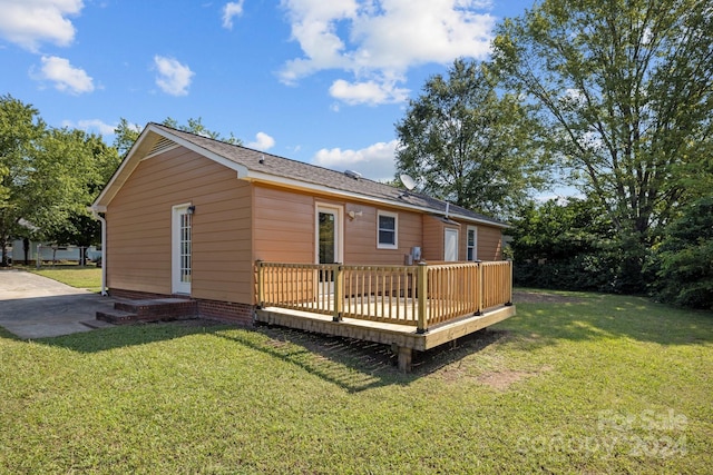 rear view of property with a wooden deck and a yard