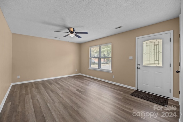 entryway with a ceiling fan, wood finished floors, visible vents, and baseboards