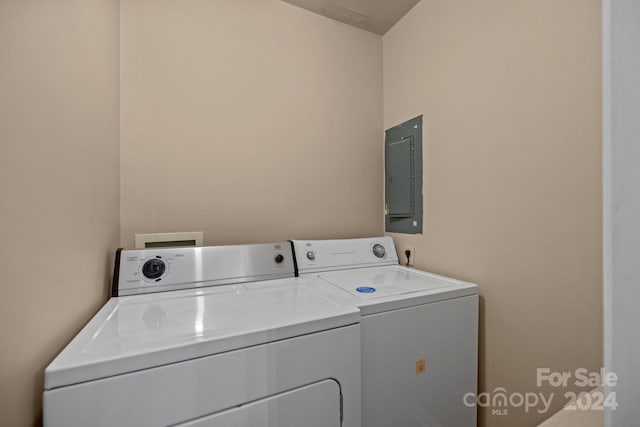 washroom featuring laundry area, electric panel, and washing machine and clothes dryer