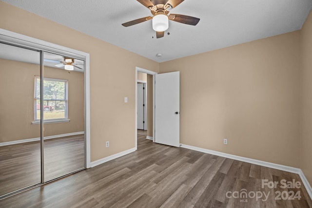 unfurnished bedroom with a ceiling fan, a closet, baseboards, and wood finished floors