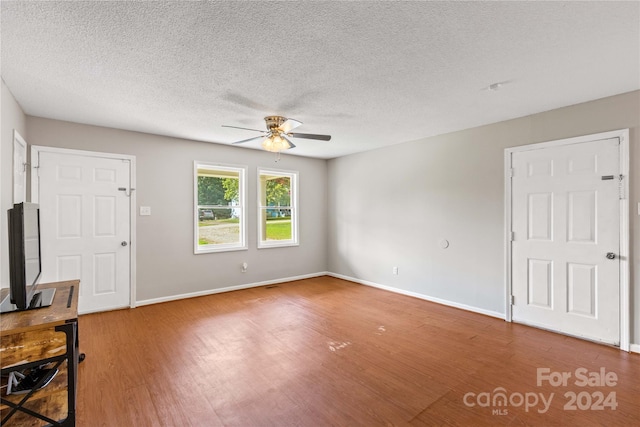 unfurnished living room with hardwood / wood-style floors, ceiling fan, and a textured ceiling