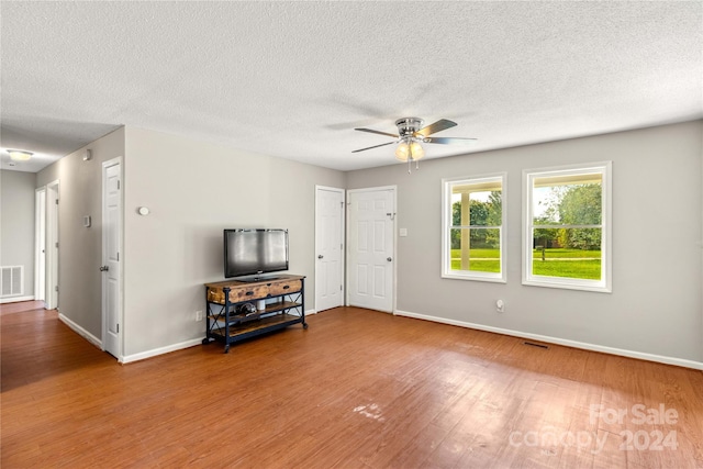 living room featuring a textured ceiling, ceiling fan, and hardwood / wood-style floors