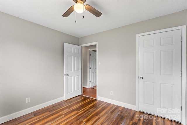 unfurnished bedroom with dark wood-type flooring and ceiling fan