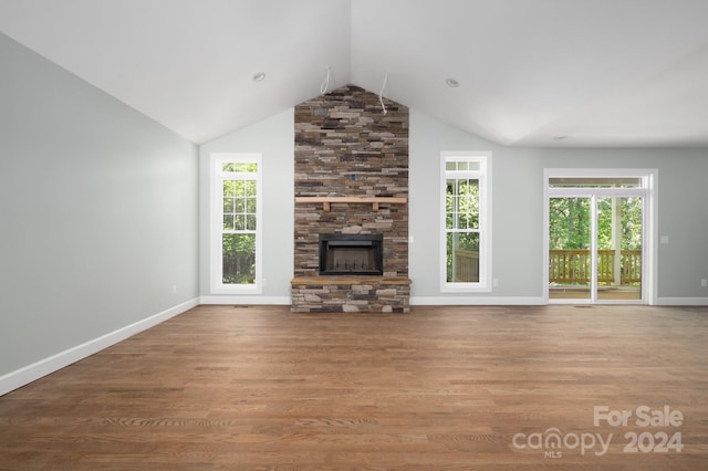 unfurnished living room featuring a stone fireplace, light hardwood / wood-style flooring, and plenty of natural light