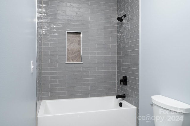 bathroom featuring tiled shower / bath and toilet