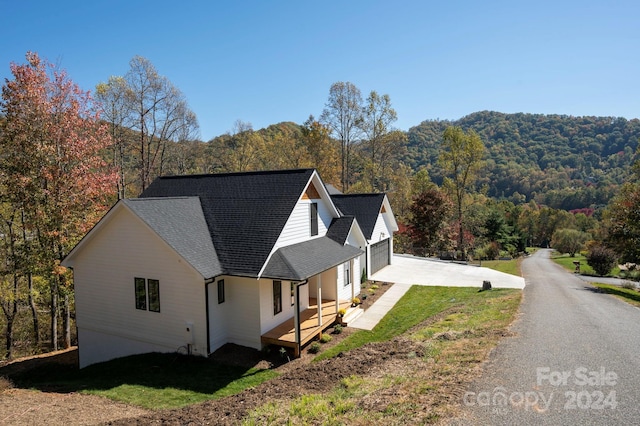 view of home's exterior with covered porch, a yard, and a garage