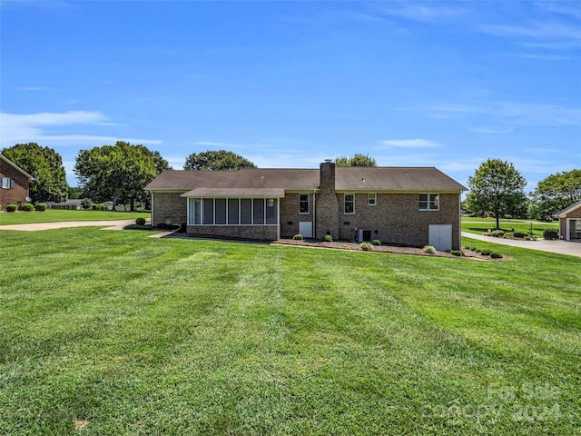 rear view of property with central AC and a lawn