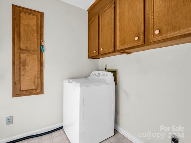 clothes washing area featuring cabinets and washer / clothes dryer