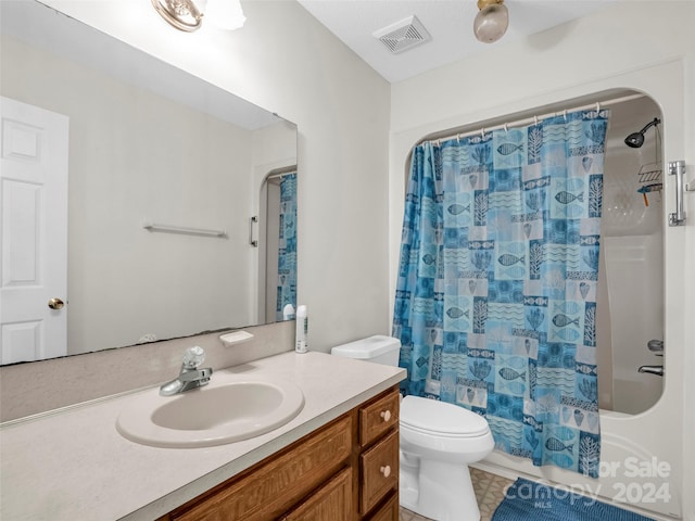 full bathroom featuring tile patterned flooring, shower / bath combo with shower curtain, toilet, and vanity