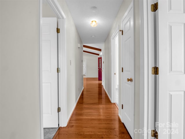 corridor featuring a textured ceiling and hardwood / wood-style flooring