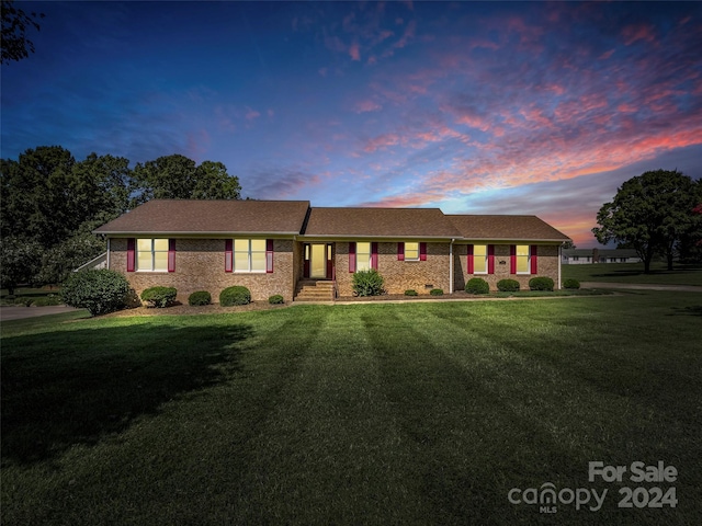 ranch-style home with a yard