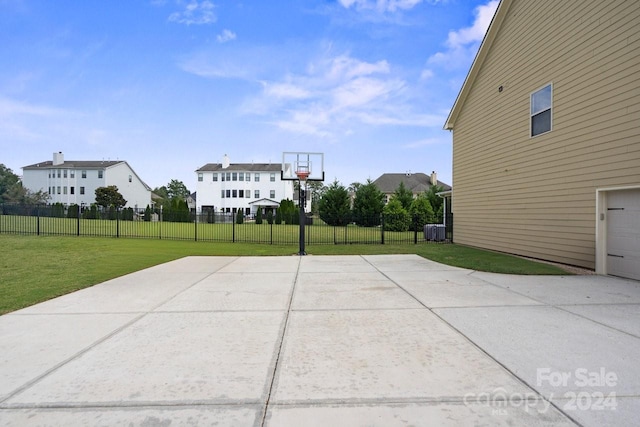 view of sport court with a yard