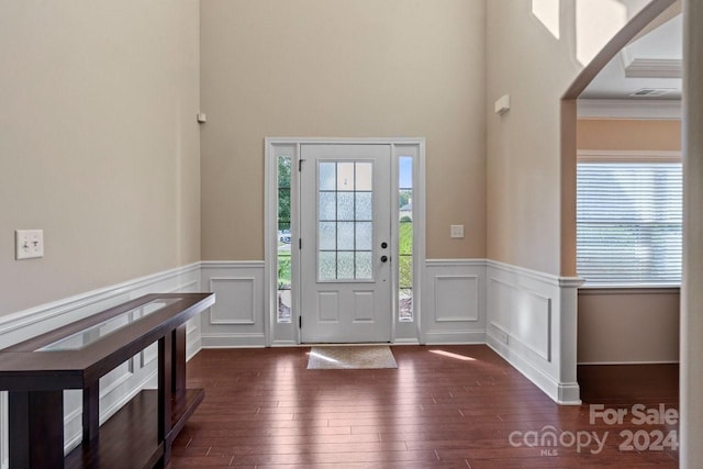 foyer featuring ornamental molding and dark wood-type flooring