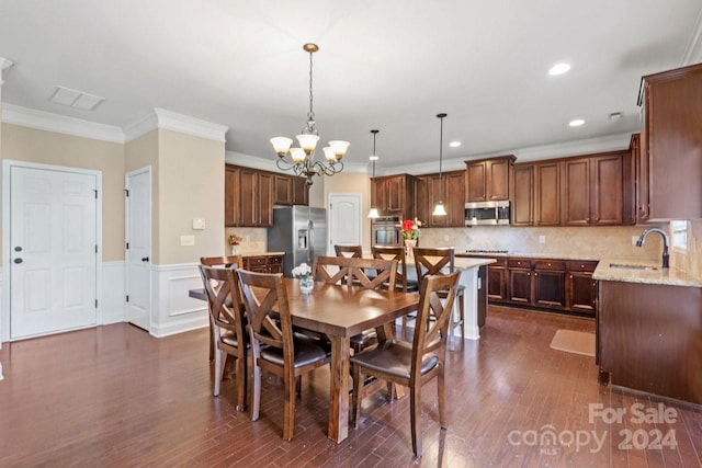 dining room with ornamental molding, a notable chandelier, dark hardwood / wood-style floors, and sink