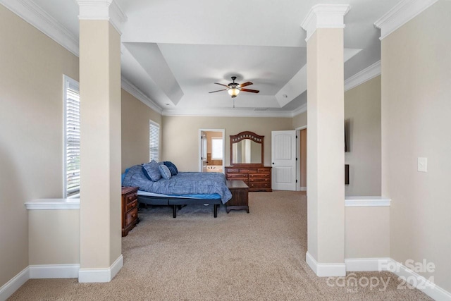 carpeted bedroom with a raised ceiling, decorative columns, ornamental molding, and ceiling fan