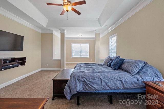 carpeted bedroom with ornamental molding, a tray ceiling, and ceiling fan