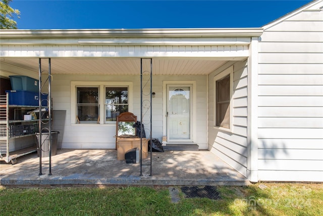 view of exterior entry featuring covered porch